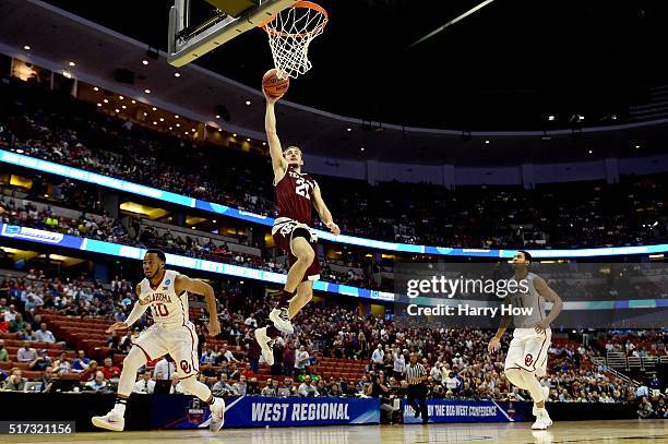 Alex Caruso of the Texas A&M Aggies goes up for a dunk between Jordan Woodard and Isaiah Cousins of the Oklahoma Sooners in the first half in the...