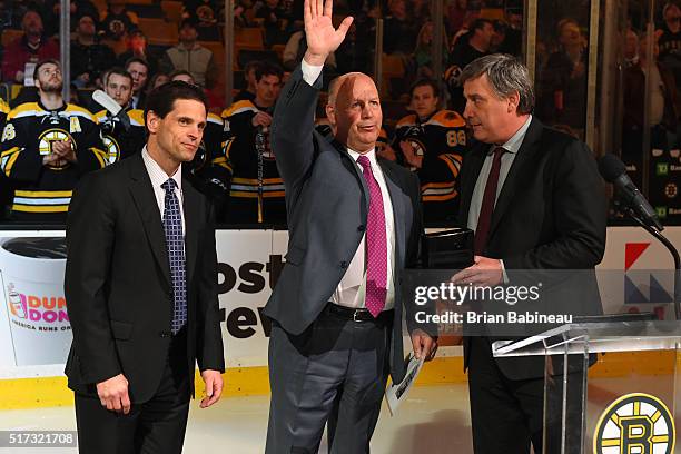 General Manager Don Sweeney, Head Coach Claude Julien and President Cam Neely of the Boston Bruins present Claude Julien with a watch for most wins...