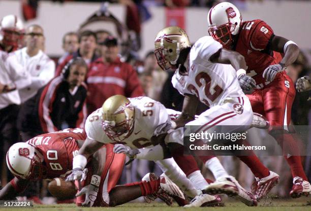 Williams of the North Carolina State Wolfpack recovers a fumble in front of Ray Piquion and Pat Watkins 322 of the Florida State Seminoles during an...