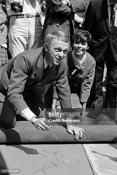 Steve McQueen writes in the cement at Grauman's Chinese Theatre on Hollywood Boulevard, prior to putting his footprints there as well. His first wife...