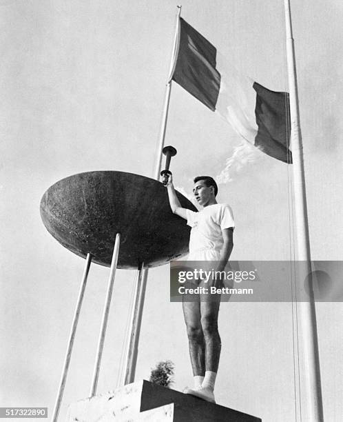 Gianfranco Peris holds up the Olympic torch after lighting the brazier in the opening ceremonies of the 1960 Summer Games.