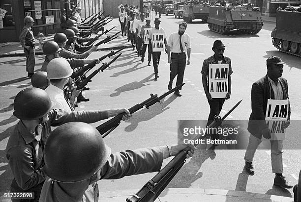 National Guard troops block off Beale Street as Civil Rights marchers wearing placards reading, "I AM A MAN" pass by on March 29, 1968. It was the...