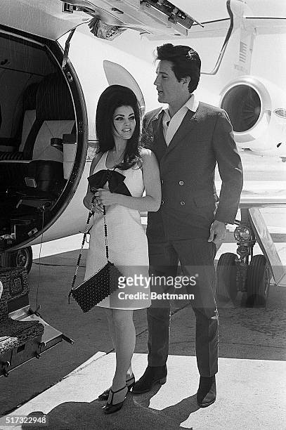 Las Vegas:Singer Elvis Presley and his bride, Priscilla Ann Beaulieu smile happily as they prepare to board a chartered jet airplane after their...