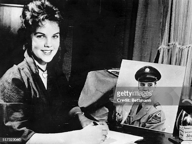 Sixteen year old Priscilla Beaulieu sits before a portrait of a uniformed Elvis Presley as she writes the singer and film star a letter. Beaulieu,...