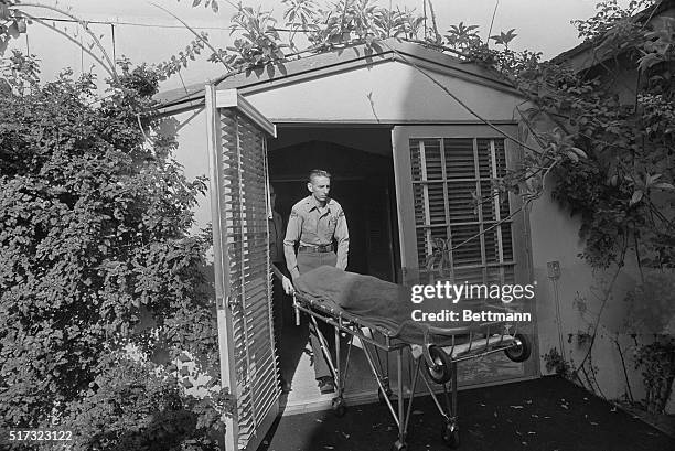 The corpse of actress Marilyn Monroe is removed to the morgue on a stretcher by a police officer. Monroe was found dead of a barbituate overdose in...