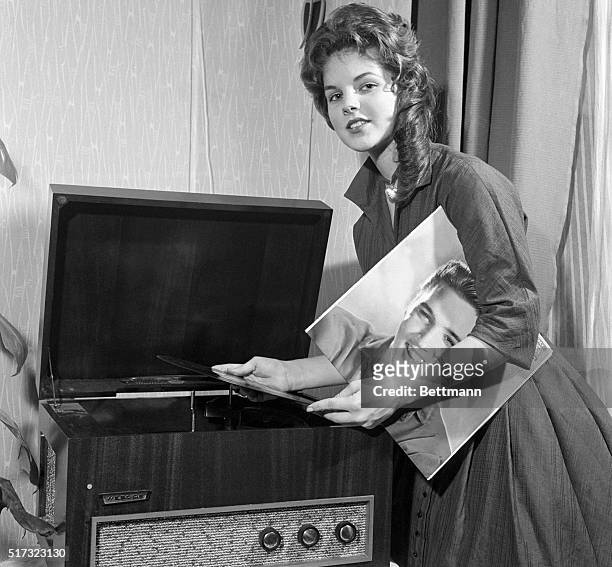 Priscilla Beaulieu, Elvis Presley's "girl back home," plays a record album by the teen idol. Elvis was serving in the US Army in Germany. The couple...