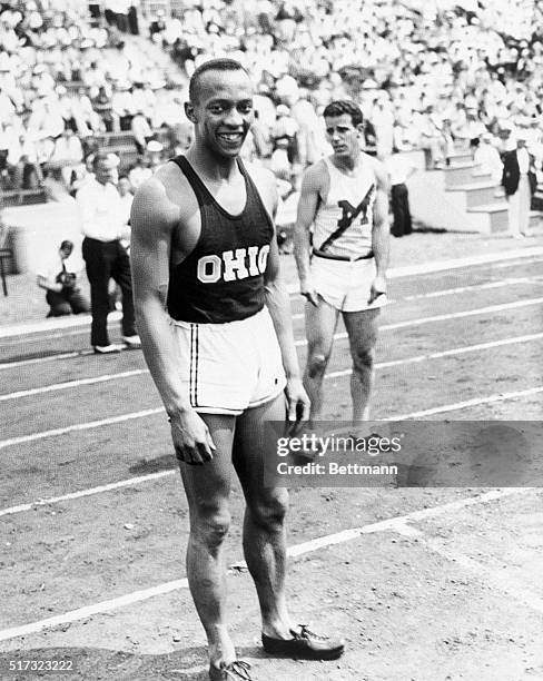 Ohio State University track star Jesse Owens stands on the track after winning the first heat of the 100-meter dash competition with a time of 10.5...