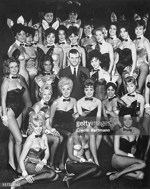 Hugh Hefner, with many of the costumed waitresses from his Playboy Clubs, known due to the outfits as "bunnies".