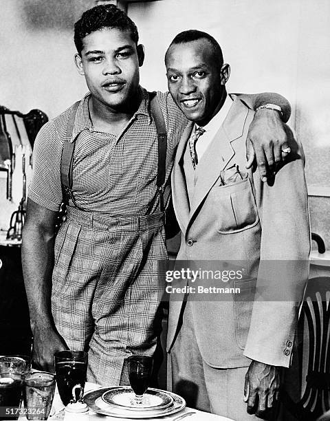 Heavyweight boxer Joe Louis puts his arm around Jesse Owens, Ohio State University track star and holder of three world's records. They were...