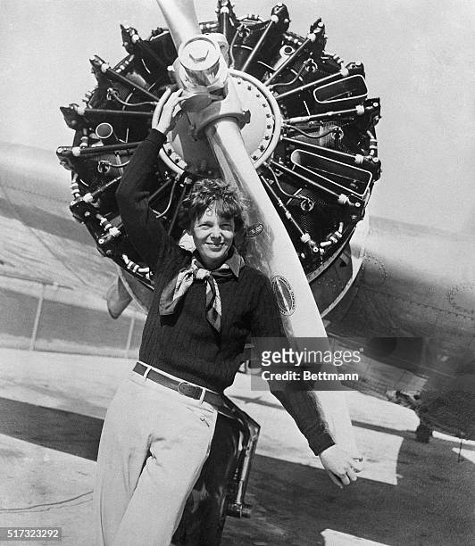 Amelia Earhart leans on the propeller on the right wing engine on her airplane. Earhart and her navigator, Fred Noonan disappeared on a flight over...