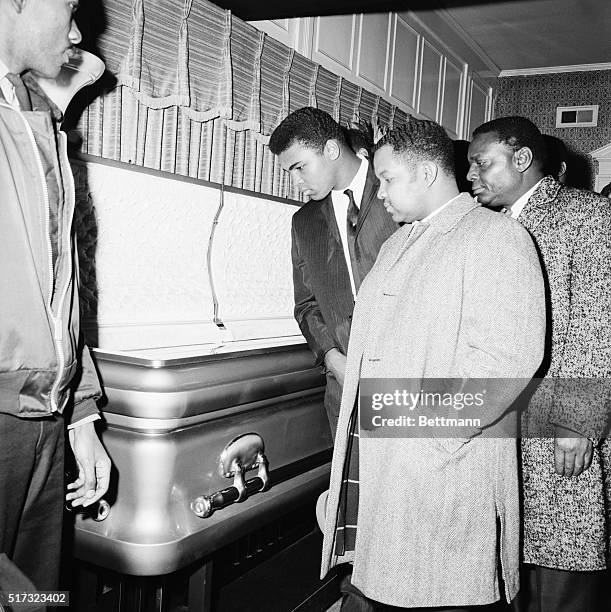 Heavyweight boxing champion Cassius Clay views the body of soul singer Sam Cooke at his wake in Chicago.