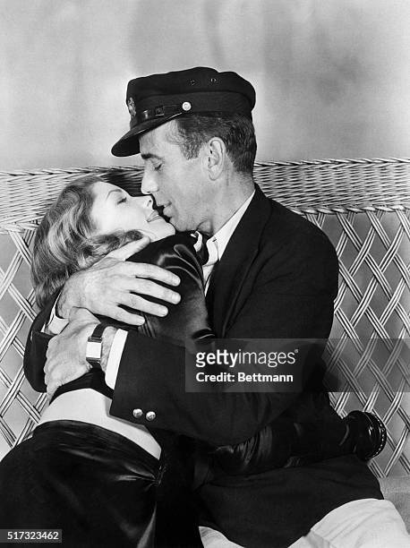 Humphrey Bogart and Lauren Bacall kiss and embrace in a scene from the film To Have and Have Not.