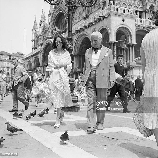 Venice, Italy: Seemingly keeping pace with a strolling pigeon, Charles Chaplin and his wife Oona enjoy themselves in famed St. Mark's Square here,...