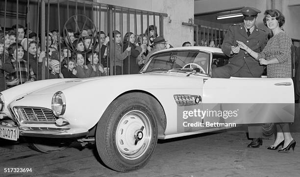 Frankfurt, Germany: Pfc. Elvis Presley of rock 'n' roll fame accepts the keys for his newly bought BMW 507 sports car from a pretty photographer's...