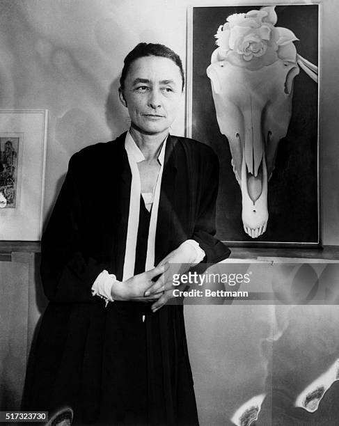 Artist Georgia O'Keeffe stands next to her painting Horse Skull with White Rose at an exhibit of her work titled Life and Death.