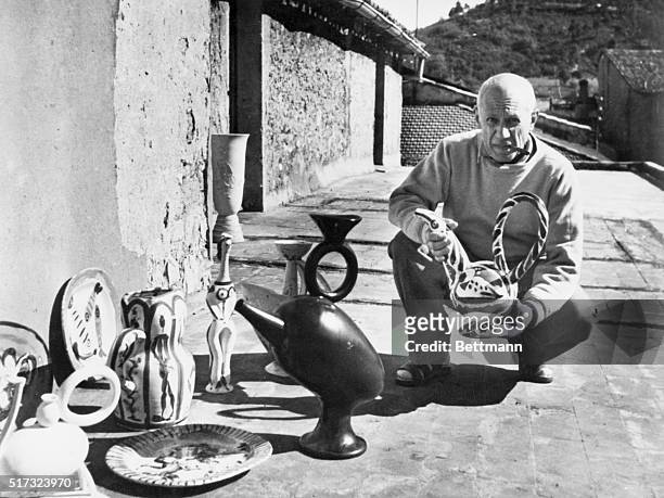 Photograph of Pablo Picasso exhibiting his painted ceramic works at his studio at Vallauris, France.