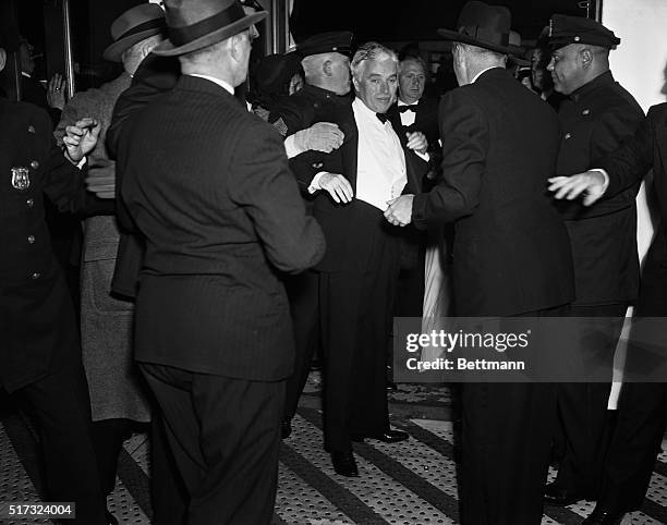 New York, NY: Actor-producer Charlie Chaplin, looking a bit dishevelled is escorted into the Astor Theater by policemen when he "fought" his way...