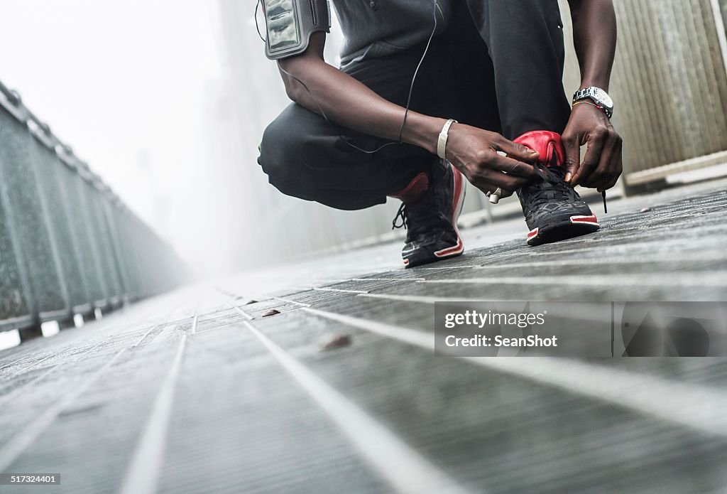 Man tying a shoe before jogging