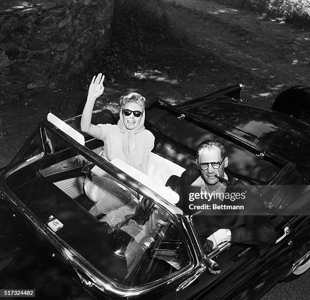 Marilyn Monroe waves from Arthur Miller's convertible as the newlyweds leave their Roxbury, Connecticut home for a picnic on the day after their...