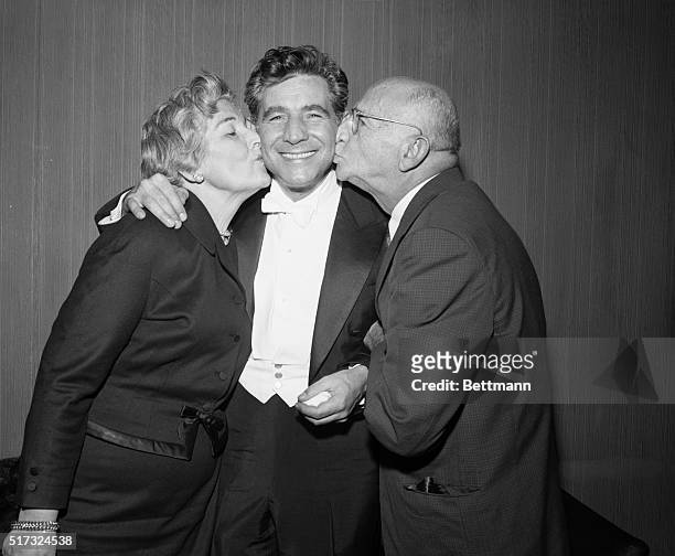 New York, NY: Mr. And Mrs. Samuel J. Bernstein proudly embrace their famed son, Leonard, after his first concert as conductor of the N.Y....