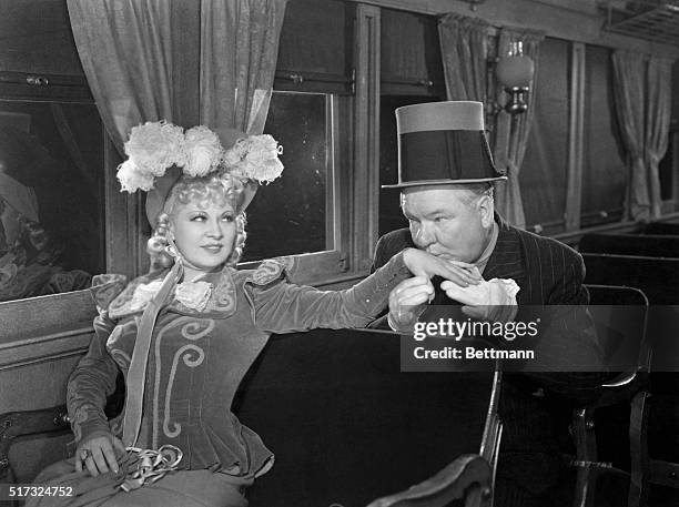 Cuthbert J. Twillie plants a kiss on the hand of Flower Belle Lee in a scene from iMy Little Chickadee/i .