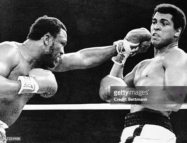 Joe Frazier reaches out with a left as Muhammad Ali pulls back during the first round of their 15-round title fight. Later Frazier suffers a TKO in...