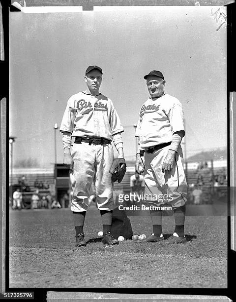 Frank Gustine , a rookie infielder and the youngest member of the Pittsburgh Pirates Spring training squad, gets some fine pointers from Honus Wagner...