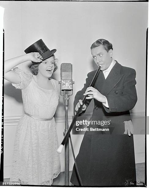 Judy Garland, diminutive songstress and comedian Reginald Gardiner are caught in rehearsal for the Metro-Goldwyn-Mayer radio show. Both artists...