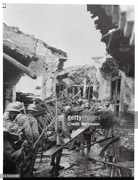 Matang, China: Japanese File Through Muddy Streets Of Matang. Japanese soldiers file through the narrow streets of Matang after a heavy artillery and...