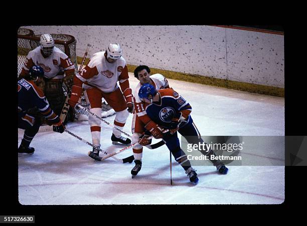 Player from the Detroit Redwings is shown holding onto Wayne Gretzky during a game between the Redwings and the Edmonton Oilers at the Nassau...