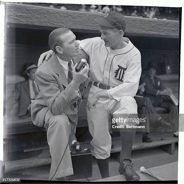 Jerome "Dizzy" Dean, without a uniform, goes into a pre-game conference with Del Baker, manager of the Detroit Tigers, who piloted the American...