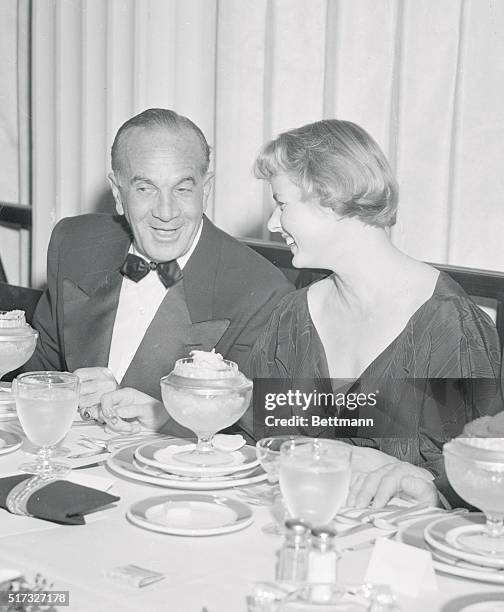 Hollywood Newsreel. Ingrid Bergman, her hair cut short for her Joan of Arc role, shown at dinner with Al Jolson.