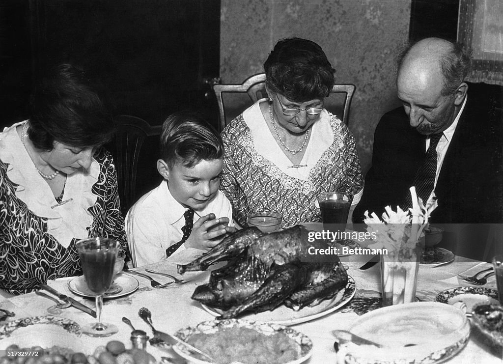 Family Saying Grace Before Thanksgiving Dinner