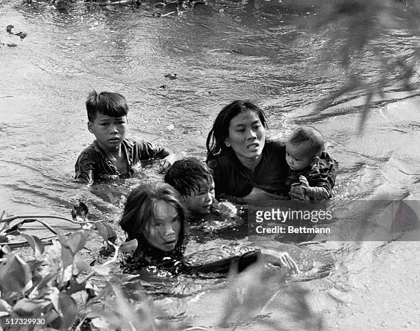 In this Pulitzer Prize winning photo, A Vietnamese mother and her children wade across a river, fleeing a bombing raid on Qui Nhon by United States...