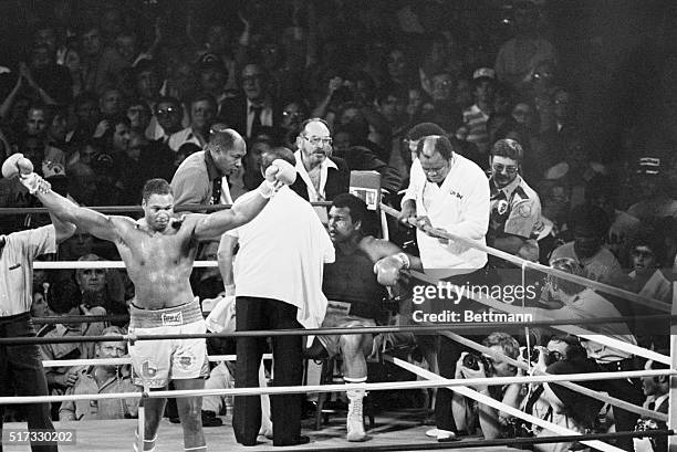 World Boxing Council Champion Larry Holmes raises his arms in victory as boxer Muhammad Ali sits in his corner unable to answer the bell for the 11th...