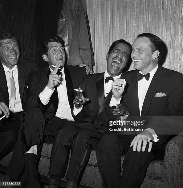 Jan Murray sits alongside Rat Pack members Dean Martin, Sammy Davis Jr., and Frank Sinatra as the group unwinds backstage at Carnegie Hall after...