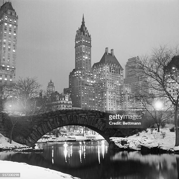 Lights glow in New York buildings as snow blankets the city and Central Park.