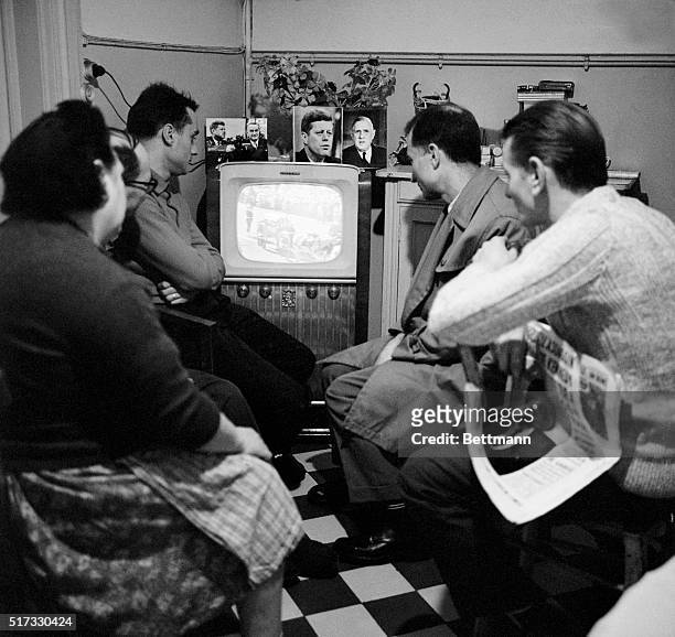 French family gathers in front of the television, adorned, with photos of the late US president John F Kennedy, to watch his funeral on November 25,...