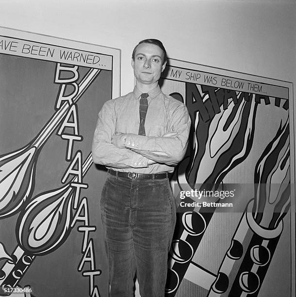 Roy Lichtenstein stands in front of his comic strip inspired work which has caption, "As I opened fire I knew why Tex had not buzzed me If he had,...