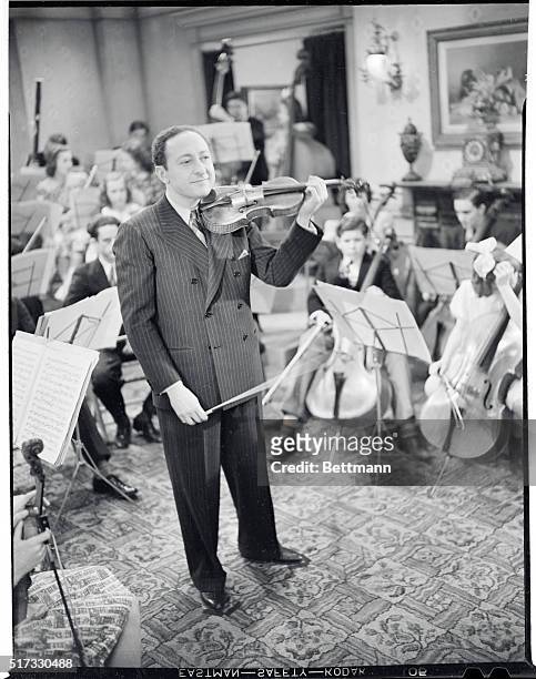 Jascha Heifetz, with members of California Junior Symphony Orchestra in scenes from his debut film, "Music School," produced by Samuel Goldwyn.