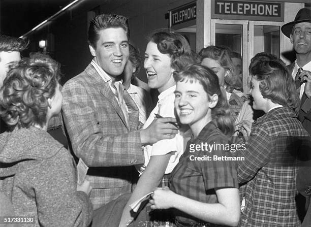 North Little Rock, Arkansas: Elvis Presley laughs after an unidentiifed fan asked him "to autograph me," because "I don't have any pencil and paper."...