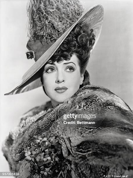 Head and shoulders of Gypsy Rose Lee in Feathered period hat and fur shawl.