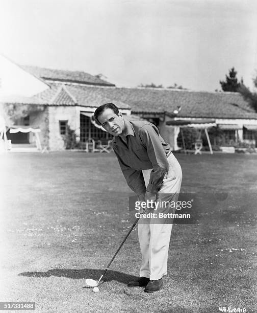 Humphrey Bogart , actor, in undated publicity still playing golf.