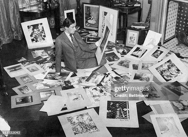 London society photographer, Cecil Beaton, sits on the floor making a choice from hundreds of pictures for an exhibition in New York.