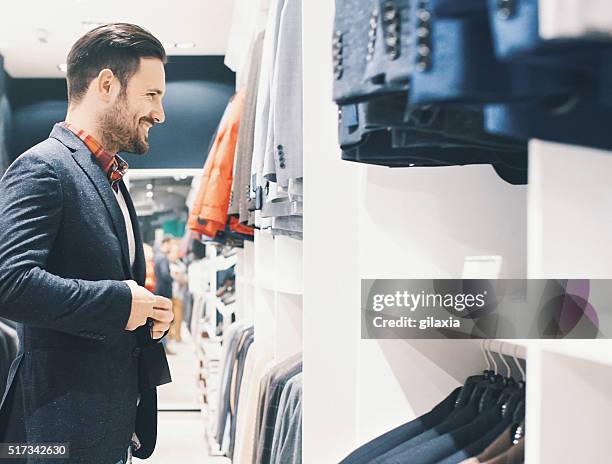 smiling handsome man buying clothes. - square one mall stock pictures, royalty-free photos & images