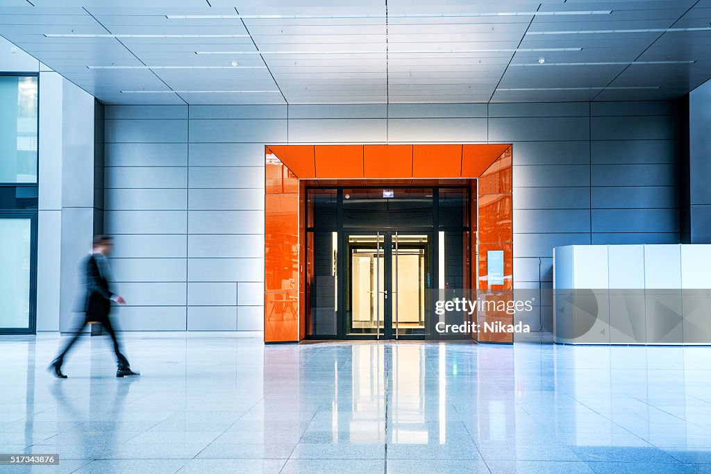 Verschwommene Geschäftsleute gehen in einem modernen Gebäude