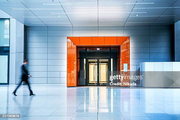 borrosa empresarios caminando en el interior de un edificio moderno - entrance fotografías e imágenes de stock