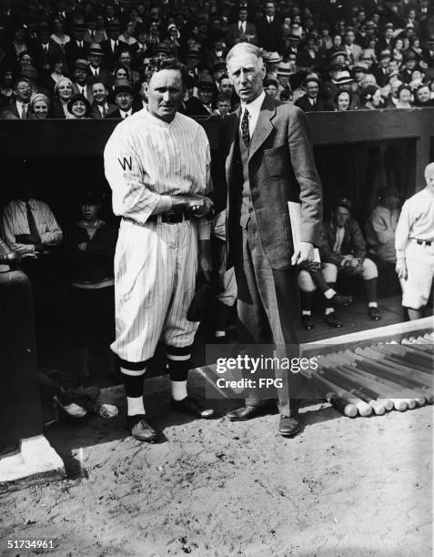 American baseball player Walter Johnson , pitcher for the Washington Senators, and Philadelphia Athletics manager Connie Mack shake hands near the...