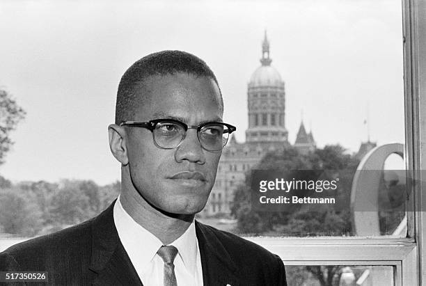Hartford, CT: Malcolm X, leading spokesman for the Black Muslim movement, is shown with the dome of the Connecticut Capitol behind him as he arrived...