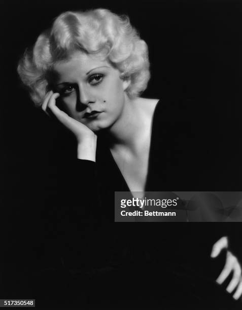 Portrait of Jean Harlow in a pensive pose, wearing a black v-necked dress. Undated photograph.